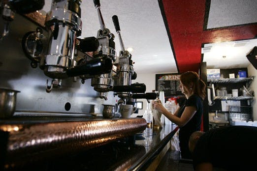 Jen Albright cleans a syrup bottle on Monday at Caf&eacute; Giuseppe. The shop was recently awarded Best Espresso Italiano by Albuquerque Magazine. 