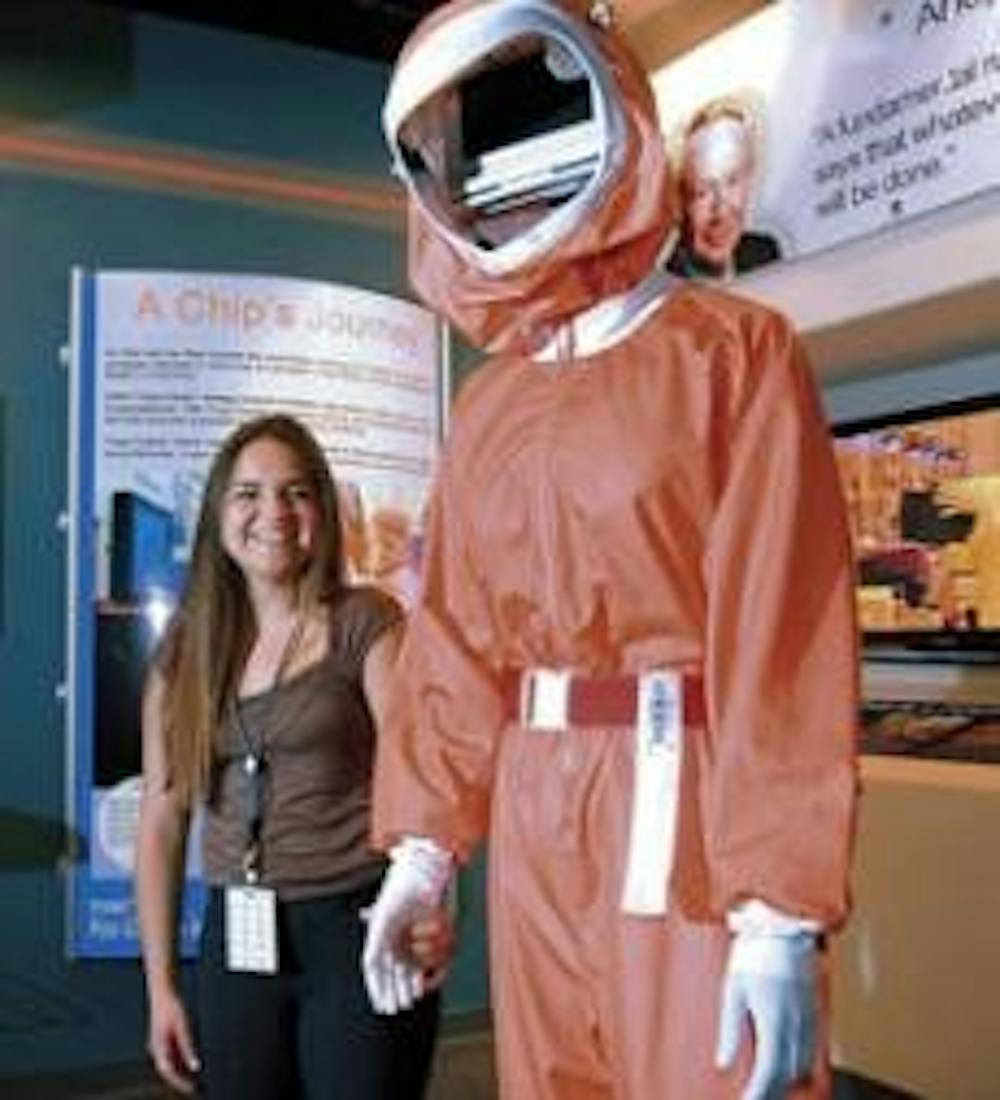 Jessica Van Why stands next to a clean-room suit at Intel's Innovation Center in Rio Rancho on Wednesday. She has interned at the company's finance department since February.