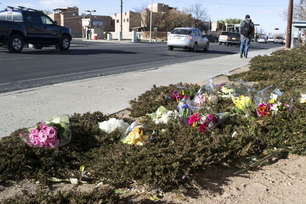 Flowers scattered on bushes create a makeshift memorial in front of Hotel Albuquerque on Sunday. A stolen truck collided with a car that contained the four UNM students on Friday night, killing two and critically injuring the others.