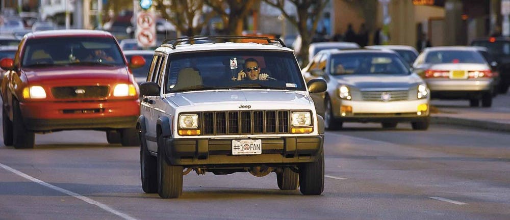 A man talks on his cell phone while driving Monday on Central Avenue. A bill that bans handheld cell phone use while driving a vehicle was signed by Mayor Martin Ch&aacute;vez on Monday. The Albuquerque Police Department will issue warnings for the first 