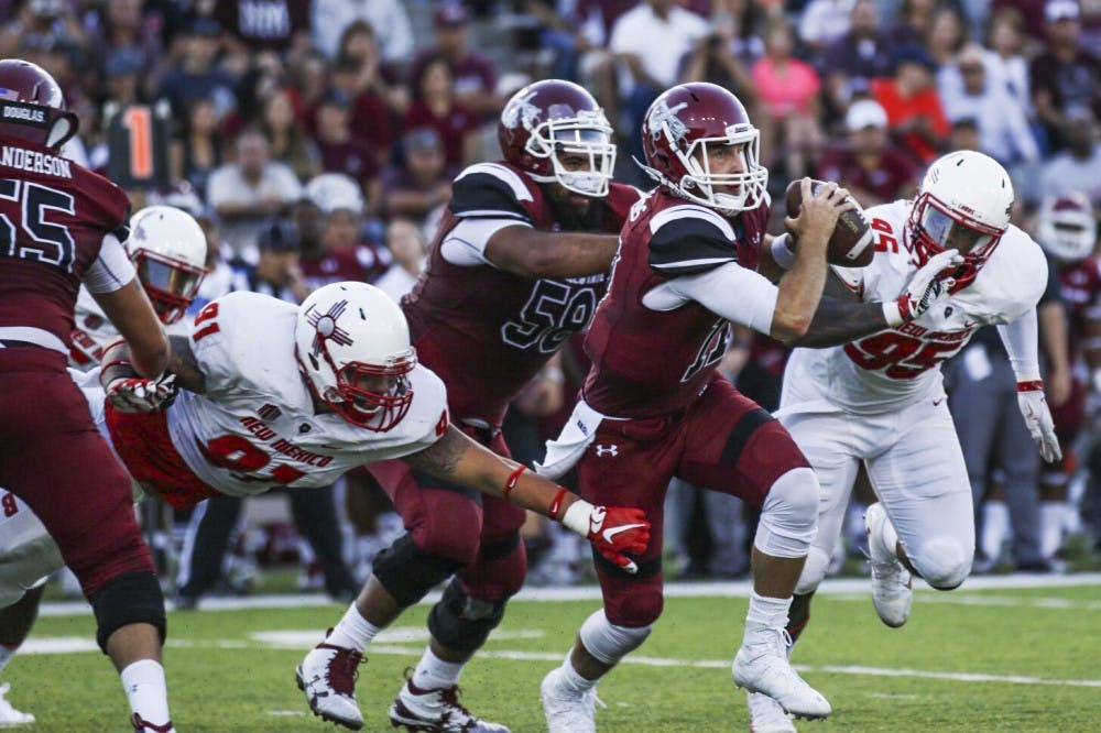 NMSU senior quarterback Tyler Rogers looks for an open player as Lobos chase him down Saturday, Sept. 10, 2016 in Las Cruces, New Mexico. The Aggies had a slow start in the Rio Grande Rivalry, but finished on top 32-31.