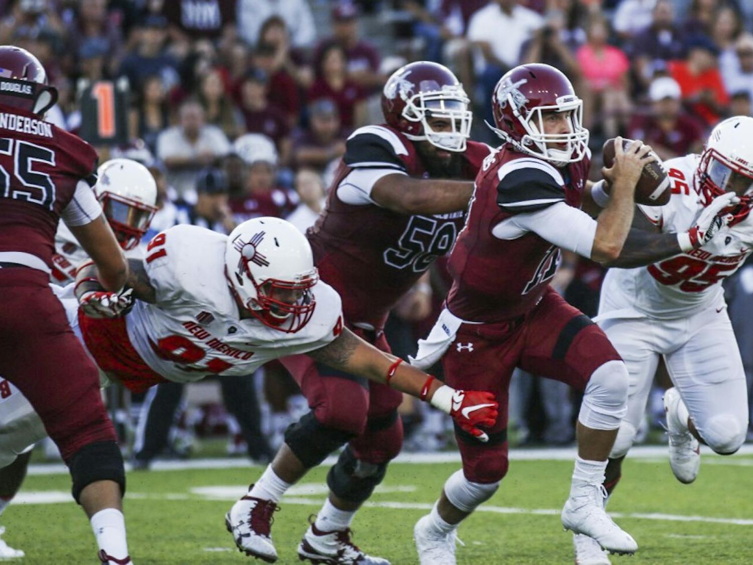 NMSU senior quarterback Tyler Rogers looks for an open player as Lobos chase him down Saturday, Sept. 10, 2016 in Las Cruces, New Mexico. The Aggies had a slow start in the Rio Grande Rivalry, but finished on top 32-31.