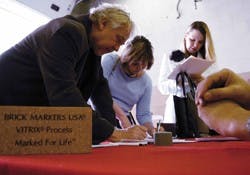 Steve Borbas, left, who works for facility planning at UNM, donates money for the renovation of the communication and journalism building on Friday. Donors' names will be engraved on bricks outside the building once construction is done.