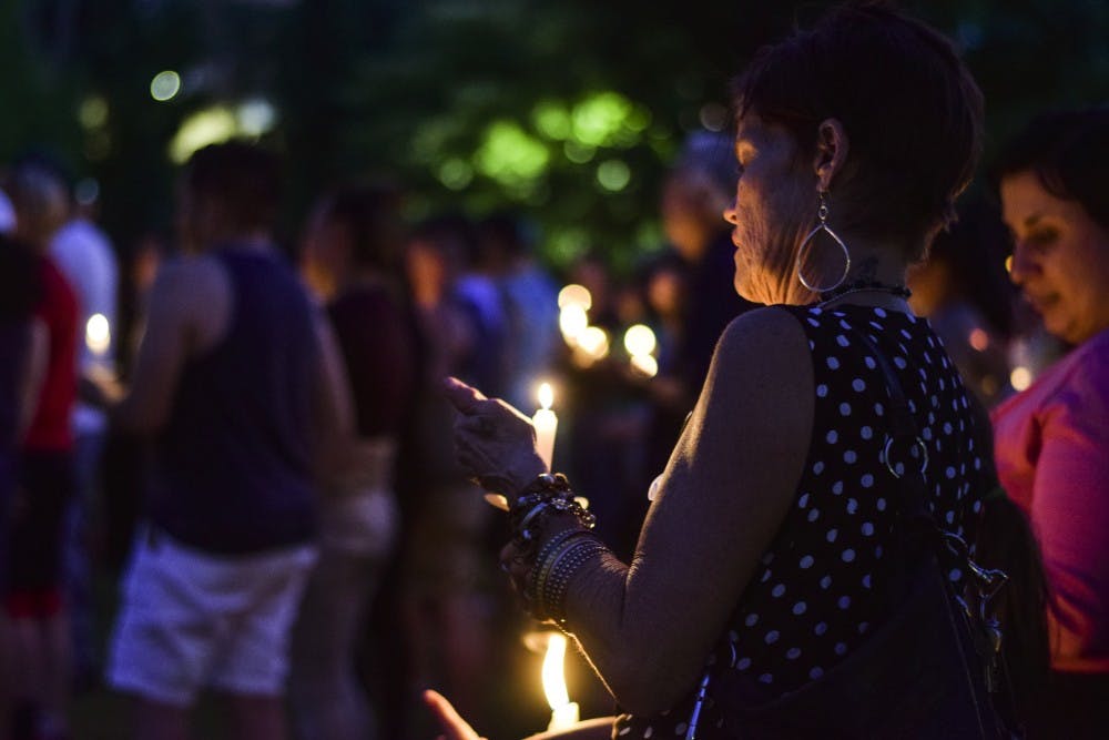 Vigil attendees light candles on Thursday night at the UNM Duck Pond. The vigil was held in memory of those who lost their lives during Sunday’s shooting in Orlando, Florida.