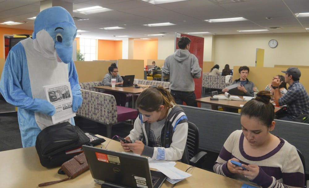 Gabriel Saenz roams around campus wearing a dolphin suit in order to grab students attention and ask them to text I 