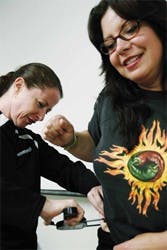 Ginny Wilmerding, left, does a skin-fold test to measure Glinda Wyndorf's body fat at the Johnson Center on Wednesday. Wyndorf, assistant of the dean at the College of Fine Arts, joined an eight-week program based on NBC's "The Biggest Loser." The program