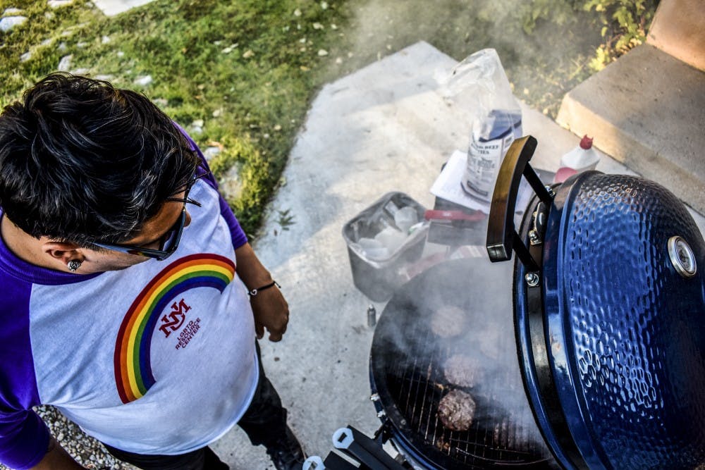 An LGBTQ Resource Center staff member grills to celebrate National Coming Out Day.
