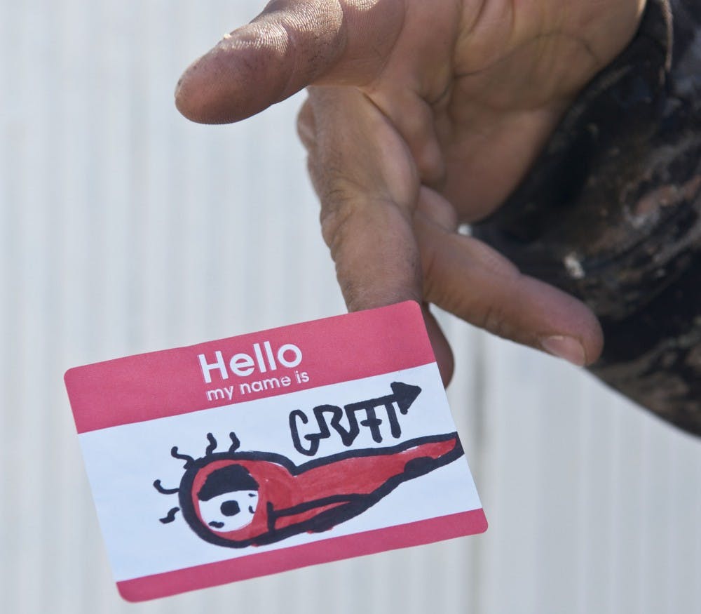  A City of Albuquerque worker removes stickers from city property. Stickers are considered graffiti, according to Graffiti Removal Services.