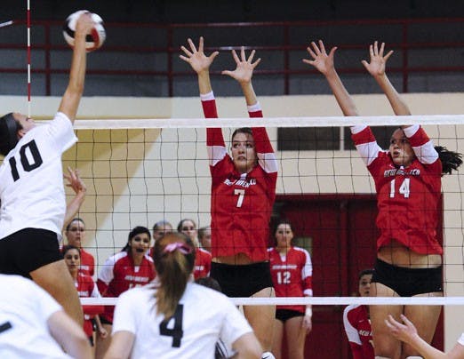 Former UNM volleyball player Jeanne Fairchild, left, looks to spike the ball as Lobos Jade Michaelsen, center, and Anna Lehne defend UNM's side of the net. The Lobos went 6-0 in their spring tournament and defeated a Fairchild-led alumni team.