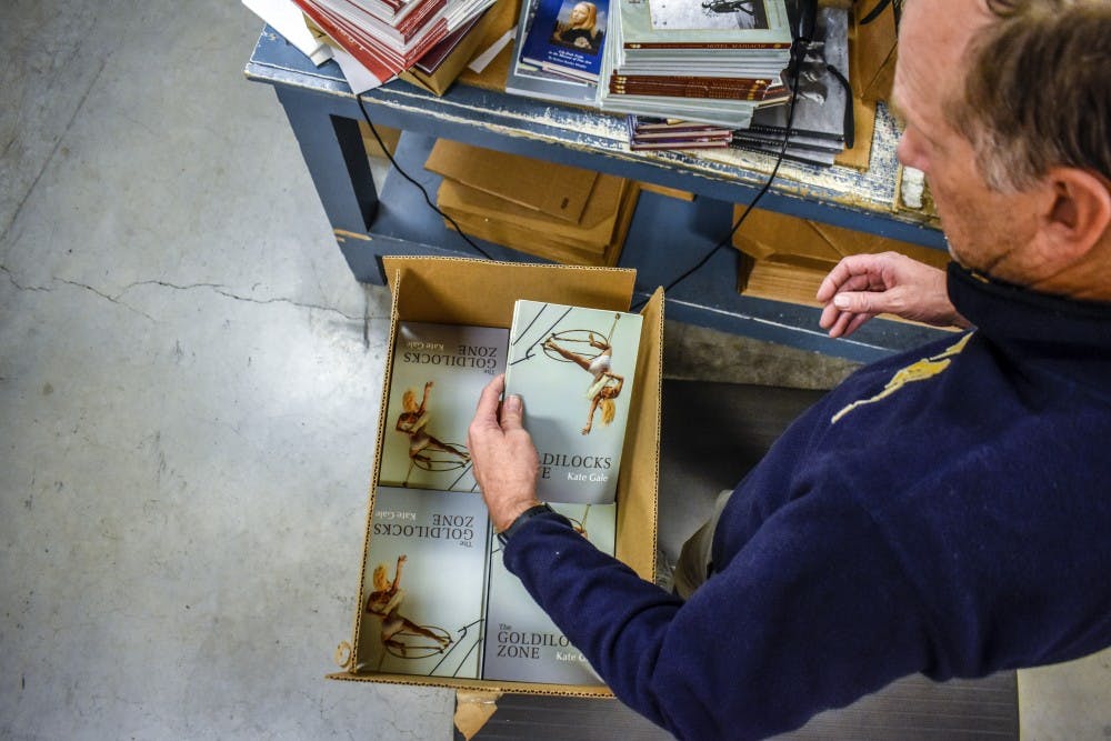 Larry Plumlee unpacks books at the University of New Mexico Press.