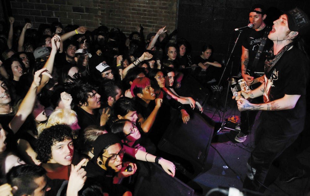 Scott Sturgeon, right, lead singer of the punk band Leftover Crack, sings "Rock the 40 Oz." to a sold-out crowd at the Launchpad on Monday. 