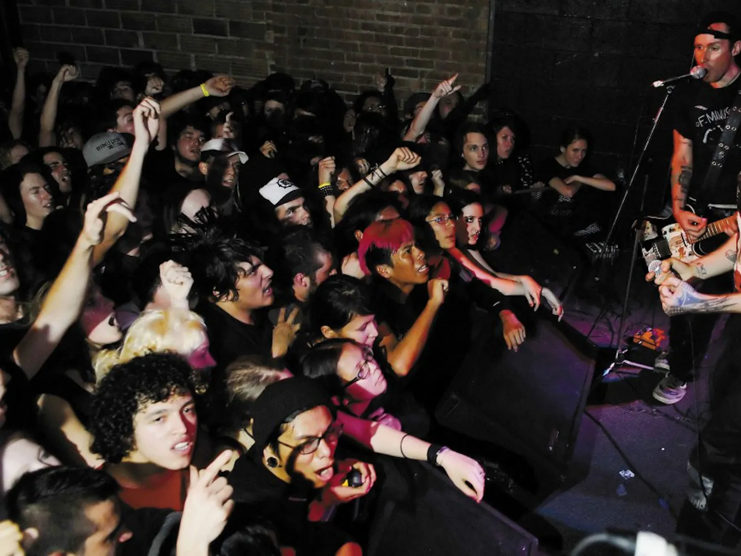 Scott Sturgeon, right, lead singer of the punk band Leftover Crack, sings "Rock the 40 Oz." to a sold-out crowd at the Launchpad on Monday.