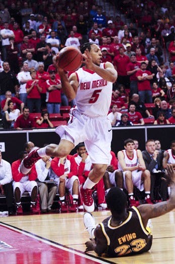Dairese Gary plows over Wyoming's Brandon Ewing on Thursday in Las Vegas, Nev. Gary showed his grit against the Pokes, scoring 20 points, seven coming in the last 1:50 of the game. But the Lobos fell short, 75-67.