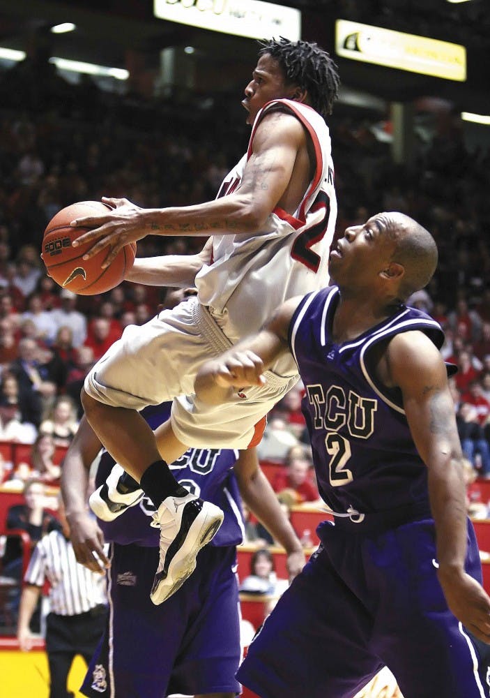 UNM guard Darren Prentice jumps for a layup over Texas Christian's Brent Hackett during Saturday's game at The Pit. The Lobos won 74-58. 
