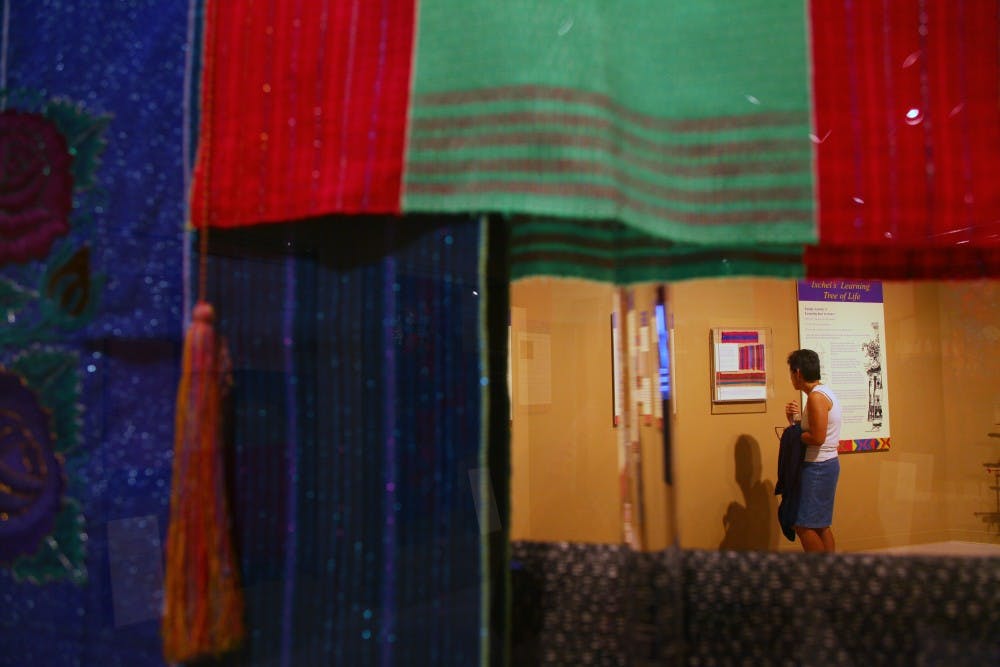 	UNM staff member Cindy Mortensen looks at the Mayan weaving exhibit at the Maxwell Museum of Anthropology on Wednesday. The exhibit focuses on the differences in textile production in southern Mexico over the past two decades. 