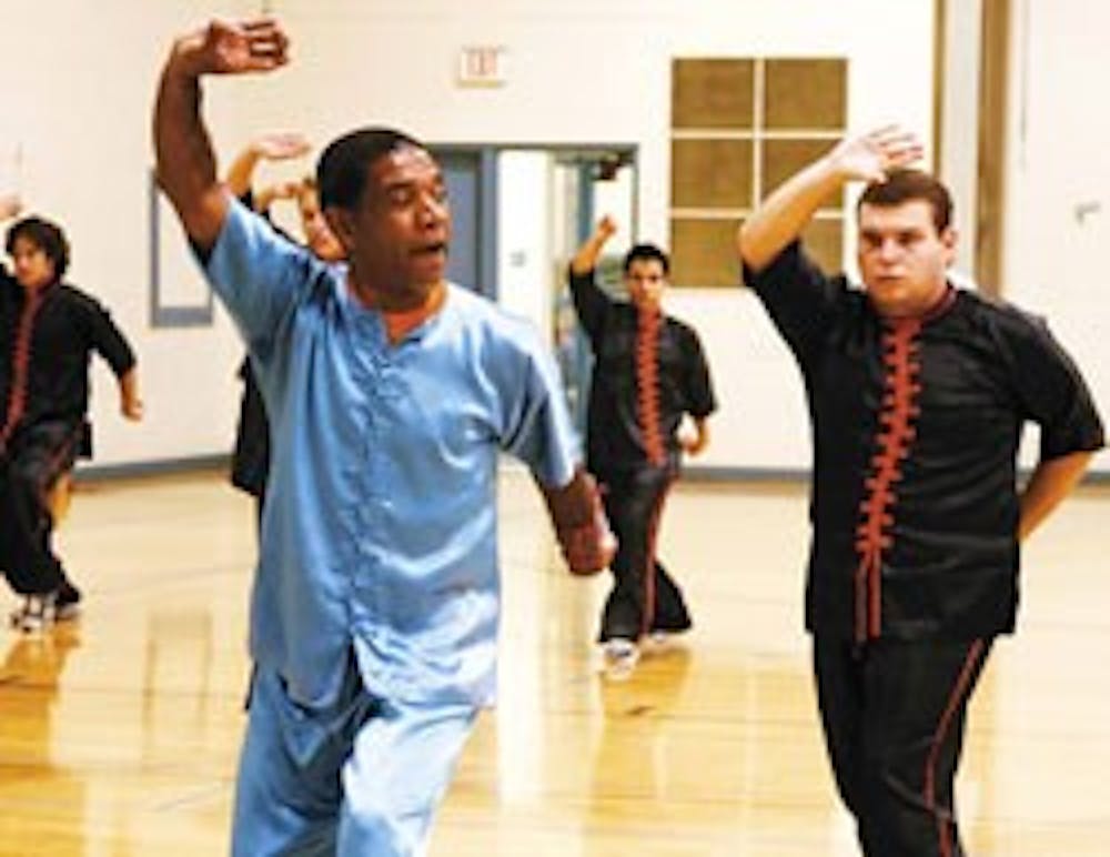 Kung fu instructor Jamal Morris, left, leads his class at Johnson Center on Thursday, while student Christian Finch, right, follows.