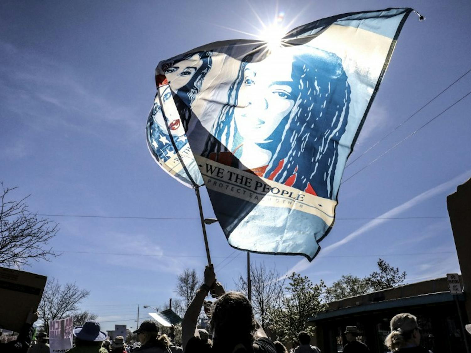 Babs Jaramillo waives a “We the People” flag during Saturday’s nationwide “March for Our Lives” event on March 24, 2018. Albuquerque participants began marching in Old Town before heading to Tiguex Park where Mayor Tim Keller and others spoke.&nbsp;