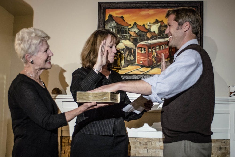 Mayoral Elect Tim Keller places his hand on a bible his mother Janet Keller is holding while District Judge Shannon Bacon swears him into office, during a ceremony held at his private residence, November 30, 2017. 
