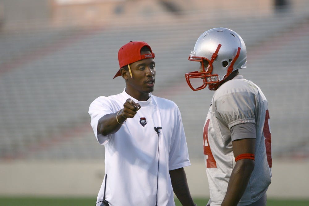 	Wide receivers coach J.B. Gerald, left, gives instruction to Lobo wideout Ty Kirk. Gerald, who was a founding member of a group called The Stable, has incorporated techniques he learned from working with the seven other members of the group.