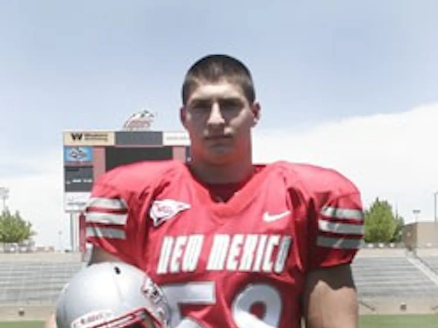 Wide receiver Daryl Jones (left) models the Lobos' new uniform during a press conference on Friday. The white jersey and cherry pant combo will be the football team's away uniform. Carmen Messina (right), posing in the home uniform, said he likes the uni