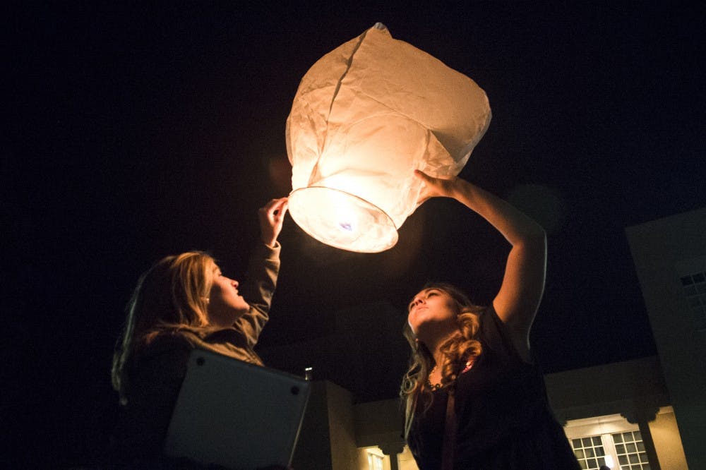 Kyla Joas, left, and Megan Seckler of Pi Beta Phi sorority raise a sky lantern outside Zimmerman Library on Tuesday evening. The launch came after the memorial service to celebrate the lives of UNM students Briana Hillard, a Pi Beta Phi sister, and Matthew Grant, a former Sigma Alpha Epsilon fraternity member. Hillard and Grant were killed and two more remain hospitalized after a hit-and-run car accident in front of Hotel Albuquerque on Friday night.