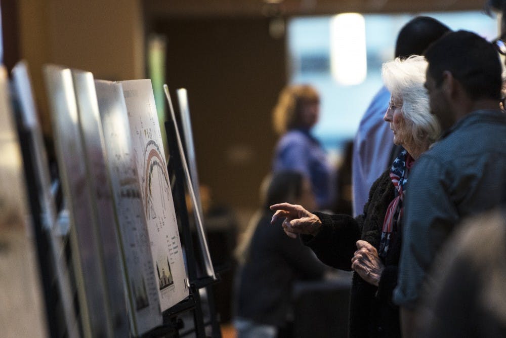 Attendees of the March 8, 2016, Albuquerque Rapid Transit meeting look through diagrams that explain various aspects of ART at the Kiva Auditorium. The transit system is projected to begin construction in September, with city officials guaranteeing that one lane of traffic will stay open during construction.