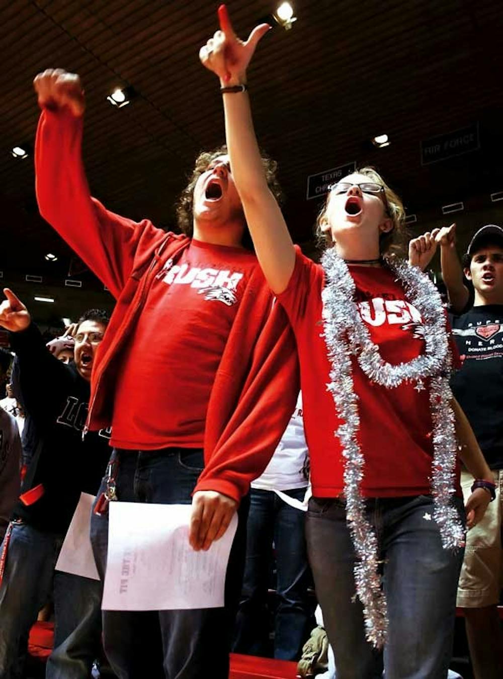 James Burkhard and Alison Trimmer cheer during a rally for the men's basketball team at The Pit on Tuesday. For a list of ticket distribution dates, see Page 3.