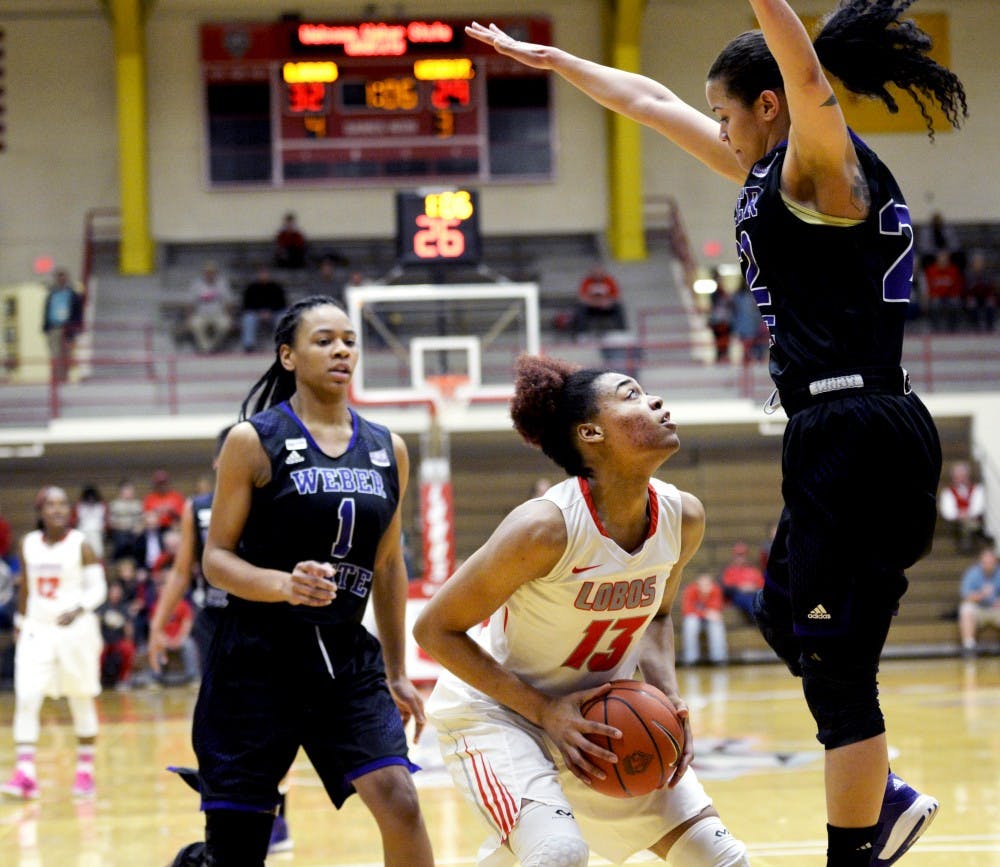 Senior forward Khadijah Shumpert evades a Weber State player as she drives to the net Wednesday night at the Johnson Center. The Lobos lost to Weber State 75-67 in the first round of the&nbsp;2016 Womens Basketball Invitational.&nbsp;
