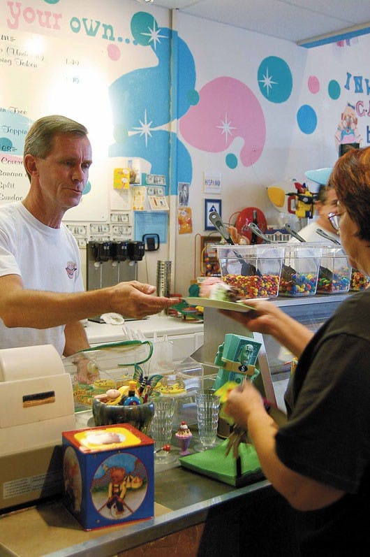 Owner Bill Warren serves a patron at I Scream Ice Cream on Saturday.