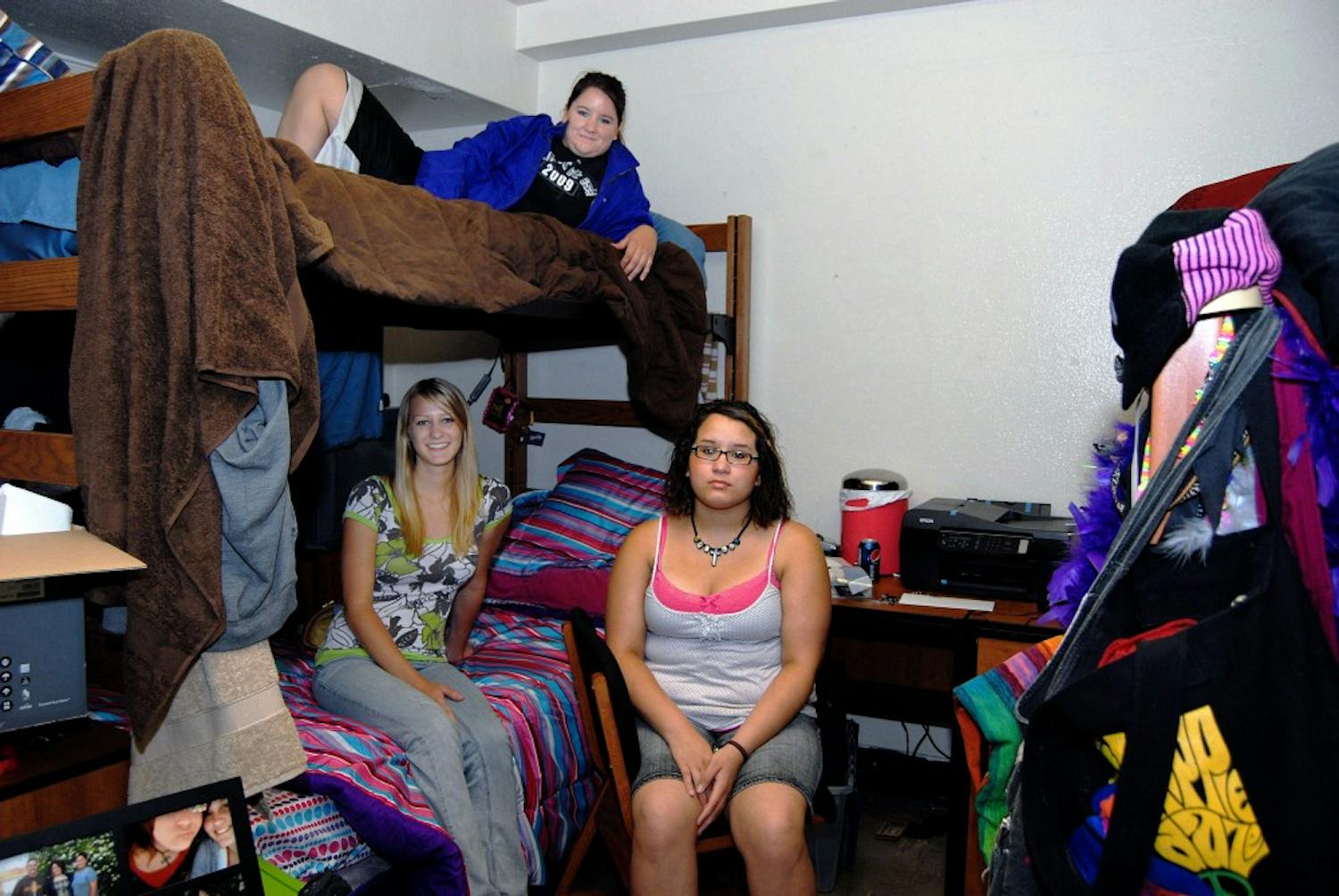 	Roommates Alana Meyer, left, Marisa Mapp, top, and Nicole A. Grimaldo hang out in their triple dorm in Coronado Hall on Tuesday. This is the first time the triple-dorm contingency plan has been implemented.