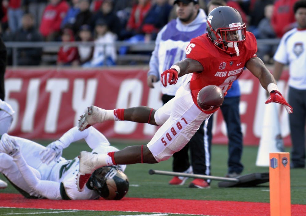 Redshirt senior Jhurell Pressley leaps into the end zone as the ball slips from his fingers at University Stadium Nov. 21. The Lobos seniors played a pivitol role in securing UNM's first bowl game since 2007.&nbsp;
