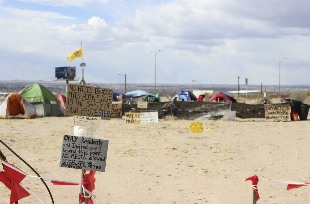 Signs are set up at the entrance of Camp Resurrection during its relocation at Lomas Boulevard and I-25. Homelessness is among the most dire issues affecting Albuquerque and the UNM area, and there is ongoing debate on how to address it. 
