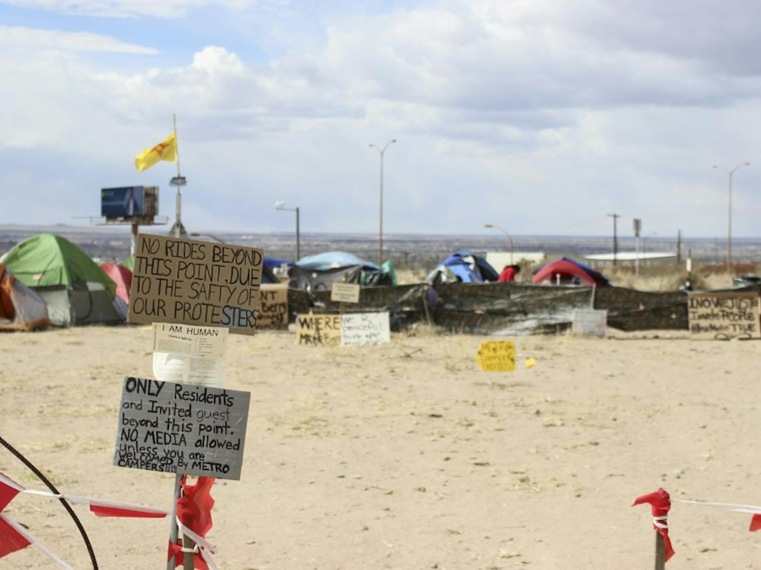 Signs are set up at the entrance of Camp Resurrection during its relocation at Lomas Boulevard and I-25. Homelessness is among the most dire issues affecting Albuquerque and the UNM area, and there is ongoing debate on how to address it. 