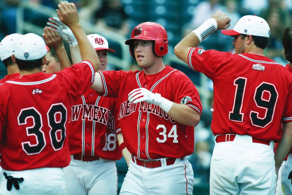 Lobo teammates congratulate first baseman Daniel Stovall, No. 34, after scoring in UNM's 19-2 victory over Hawaii-Hilo on Saturday at Isotopes Park. 