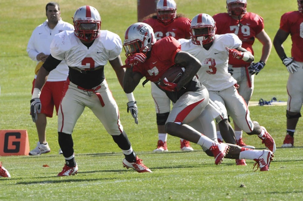Kimmie Carson, left, and fellow defensive player move into a tackle position to attempt to tackle a running back Wednesday at the Dow Tiehm Complex for football spring training. 