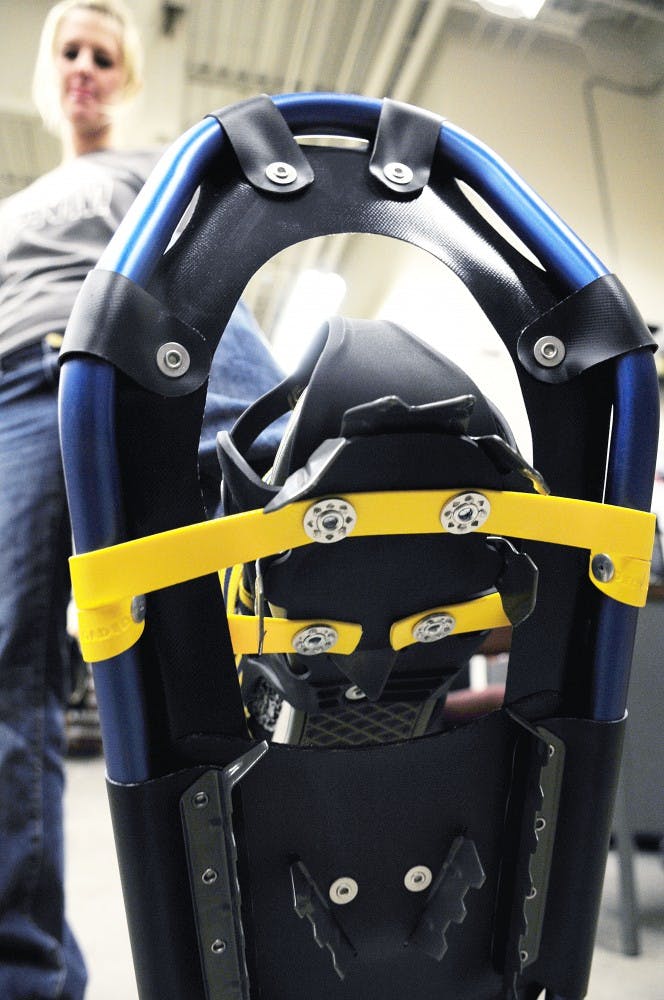 	Amy Murtagh shows off the new snowshoes at the UNM Bike Shop on Wednesday night. You can rent snowshoes for $20 per day for the full-moon hike in the Valles Caldera National Preserve on Saturday. 