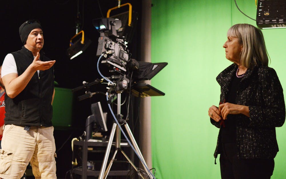 	Production staffer Manuel Machuca, left, and Director of New Media &amp; Extended Learning Debby Knotts have a conversation in the NMEL studio at Woodward Hall on Tuesday morning.