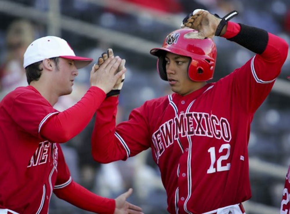 UNM pitcher Will Kerr, left, greets Rafeal Neda as he scores off a hit in the Lobos' 6-3 win over Eastern Michigan on Sunday at Isotopes Park.