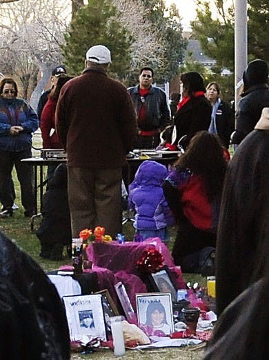 Mourners gather around a memorial altar at Robinson Park on Saturday. Families of the victims found buried on the West Mesa held a candlelight vigil at the park and encouraged each other to bring national attention to the case until it is solved.