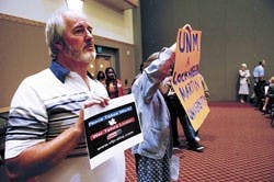 Terry Riely, left, protests at the regents meeting held in the SUB Ballroom on Wednesday.   