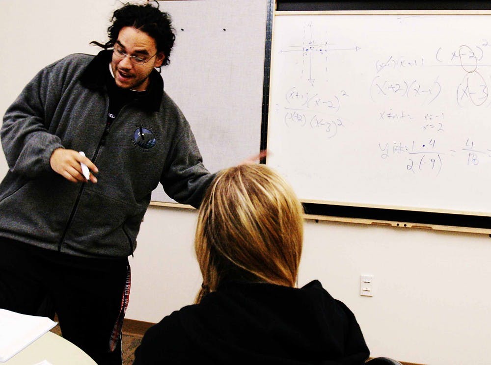 Juan Ortiz, a tutor with Student Support Services, helps Alexia Carter graph equations during the first day of Blast Off to Finals in the SUB on Monday. The week-long event offers free tutoring in math and English, massages from Apollo College students, a