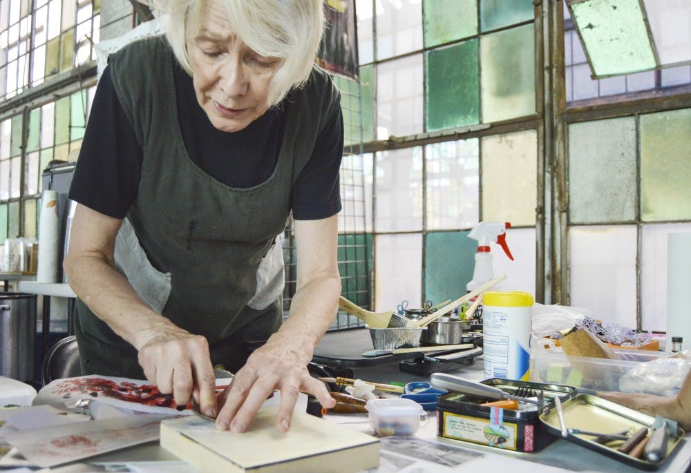 Tricia Simmons uses a spoon to burnish a piece of paper onto a cradle panel at the Rail Yards Market on Sunday afternoon. This is Simmons’ first year showcasing her art at the Rail Yards.