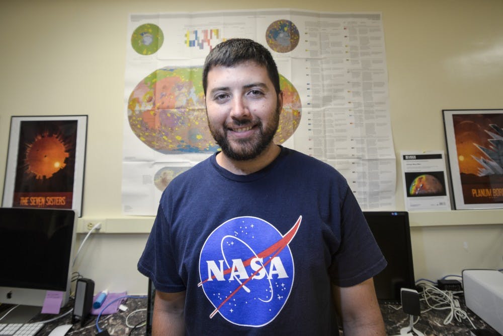 Mars One candidate Zachary Gallegos stands behind a map of Mars at a computer lab in Northrop Hall. Gallegos uses the lab to study certain aspects of Mars while he prepares for academic and personal&nbsp;endeavors.