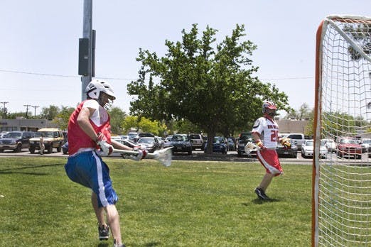 Paul Aitken, president of the UNM lacrosse team, right, and Brian Laiche circle the net on May 16 at Johnson Field. Aitken was instrumental in securing full funding for the team this year. 