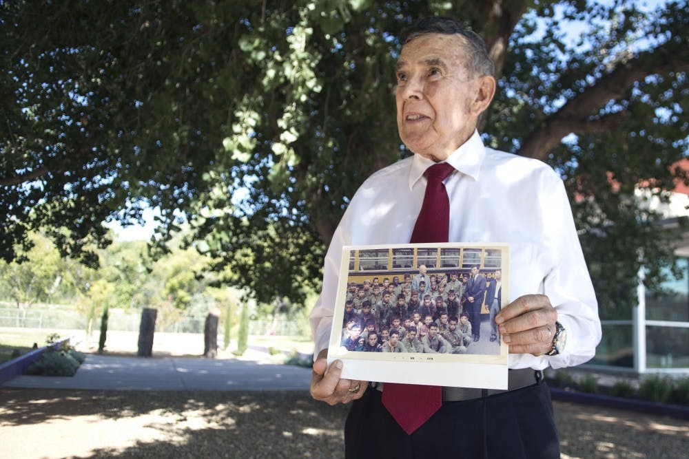 	Desi Baca holds up a photograph of Sgt. Pete Padilla and Pfc. Manuel Mora with other Boy Scouts at the National Hispanic Cultural Center on Aug. 11. Baca was scout leader at the time that Padilla and Mora were members and was present when the appropriation of funds for the memorial were purposed.