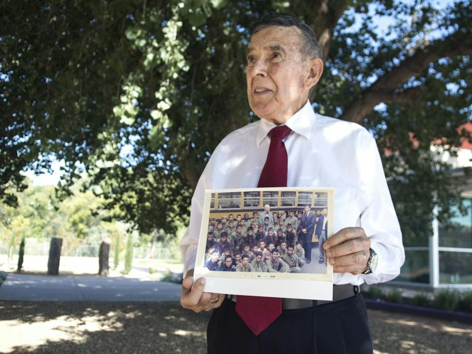 	Desi Baca holds up a photograph of Sgt. Pete Padilla and Pfc. Manuel Mora with other Boy Scouts at the National Hispanic Cultural Center on Aug. 11. Baca was scout leader at the time that Padilla and Mora were members and was present when the appropriation of funds for the memorial were purposed.