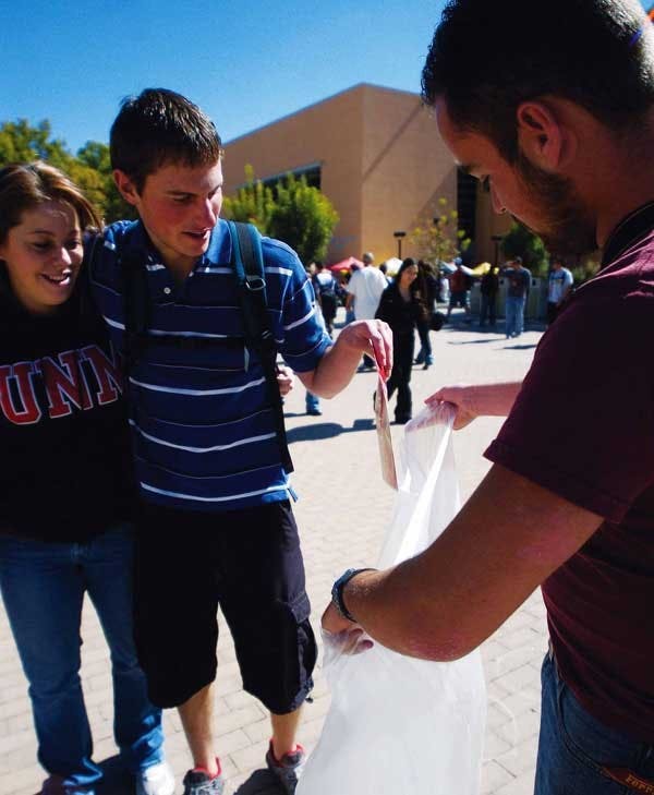Students Justin Bridges and Nicole Woods put an anti-abortion pamphlet into a trash bag held by Jason Barnes on Monday in Smith Plaza. 