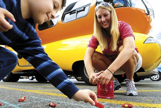 Five-year-old Andres Sedillo plays a game with Rachel Tease, one of the drivers of the Oscar Mayer Weinermobile, on Monday in a West Side grocery store parking lot.
