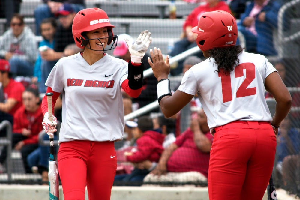 Redshirt senior Karissa Haleman celebrates with Mariah Rimmer as she makes her way back to the dugout Sunday afternoon at the Lobo Softball Field. The Lobos won two out of their three games against Utah State this past weekend.&nbsp;&nbsp;