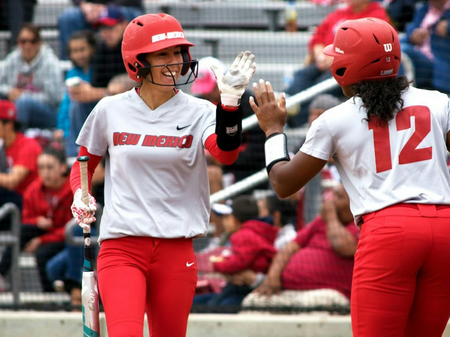 Redshirt senior Karissa Haleman celebrates with Mariah Rimmer as she makes her way back to the dugout Sunday afternoon at the Lobo Softball Field. The Lobos won two out of their three games against Utah State this past weekend.&nbsp;&nbsp;
